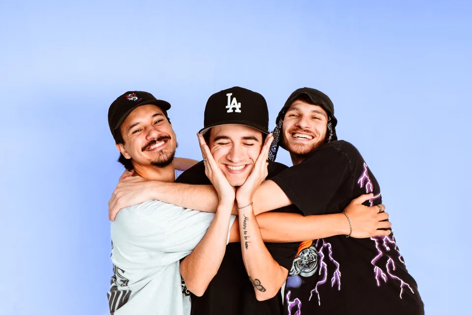 Levity’s three members leaning together against a pale blue background.